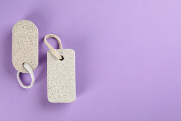 Pumice stones on violet background, flat lay. Space for text
