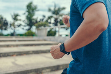 A man wearing smart watch with running up the stair in sunset.