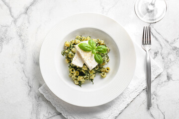 Plate with tasty pasta and spinach on table
