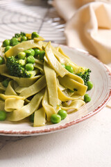 Plate with tasty pasta and vegetables on table, closeup