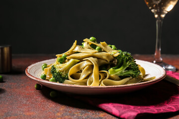 Plate with tasty pasta and vegetables on table