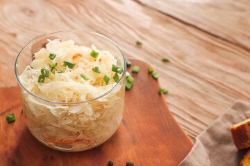 Bowl with tasty sauerkraut on wooden table