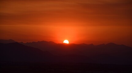 fiery sunset over the front range of the colorado mountains due to the smoke from  the western forest fires, as seen from broomfield, colorado