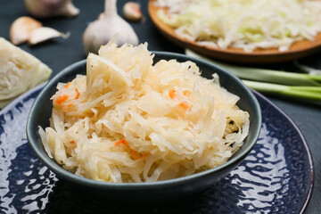 Bowls with tasty sauerkraut on table