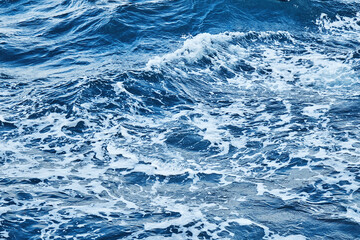 deep blue sea surface with wave by the heavy wind with many white bubble
