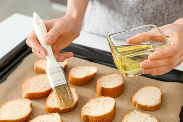 Female chef preparing toasts on kitchen table, closeup