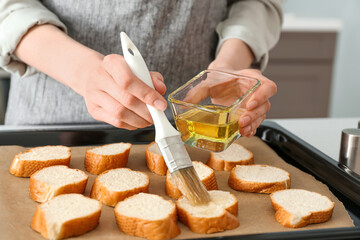 Female chef preparing toasts on kitchen table, closeup