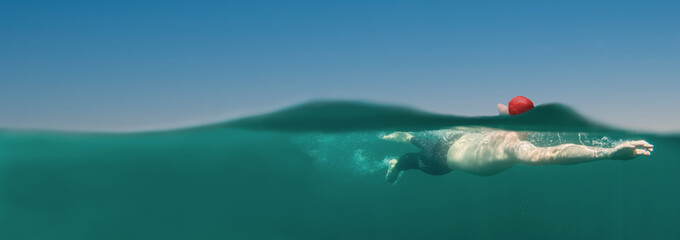 Man swimming in blue water, open water swimming