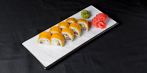 Sushi Rolls with processed cheese cheddar, american cheese, avocado, tuna and cream cheese inside on white slate
