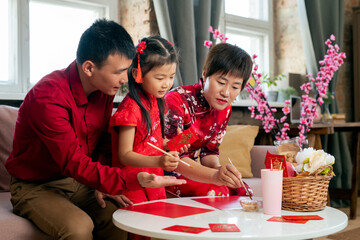 Chinese family preparing new year postcards before holiday