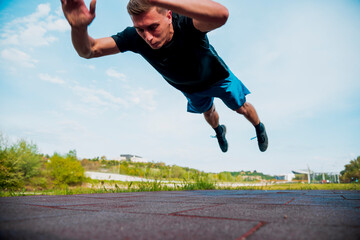 Fitness man doing clapping push-ups exercise intense training outdoors