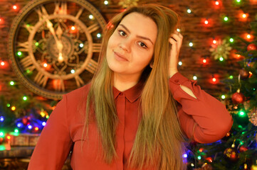 Portrait of young woman posing in room decorated to Christmas holiday