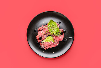 Plate with tasty veal carpaccio on color background