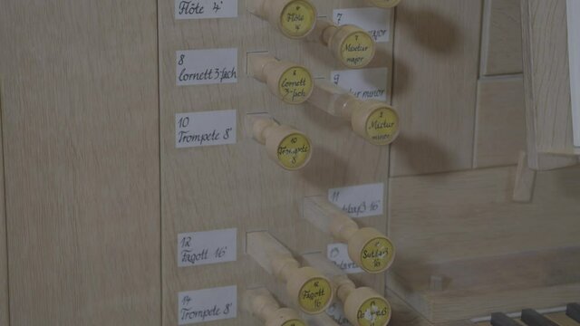 Camera panning along the stops of a wooden organ
