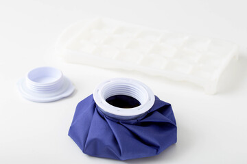A medical blue cold bag with ice next to it. Pain relief and removal of edema with bruises, therapeutic