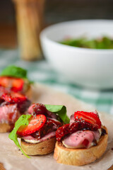 Strawberry bruschetta with prosciutto, goat cheese,basil and fresh nstrawberry on top.
