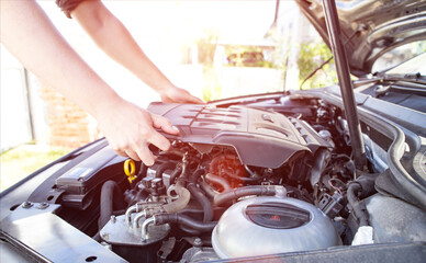 Mechanic starts repairing modern diesel car engine, background. Sun