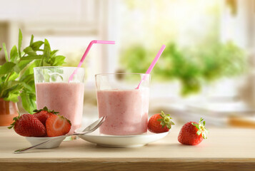 Glasses with strawberry shake on table full of fruits kitchen