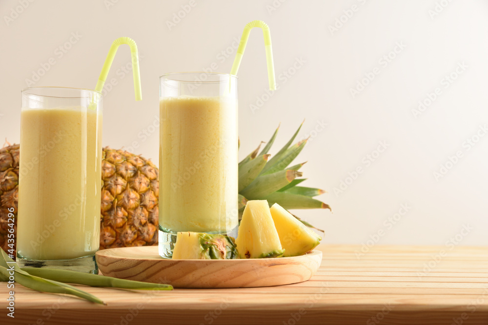 Wall mural two tall glass glasses with pineapple juice isolated background.