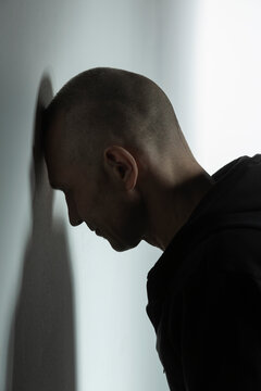 Frustrated man leaning head against wall
