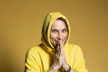 Portrait excited man in yellow hooded sweatshirt
