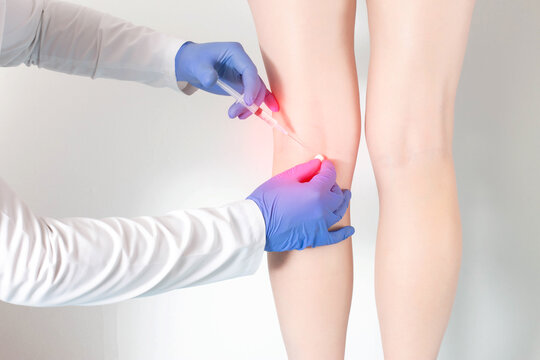 Doctor Gives An Anti-inflammatory Healing Injection In The Knee Joint To Relieve Pain And Reduce Swelling