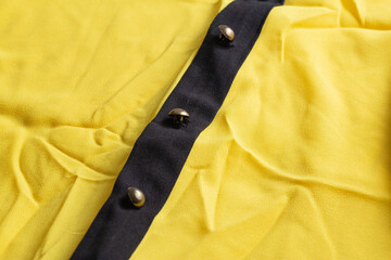 Yellow wrinkled modern fabric on the dress, macro. Fashion