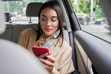 Woman looking at the smartphone screen while listening music and browsing internet