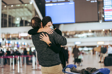 Man giving warm welcome to his wife at airport