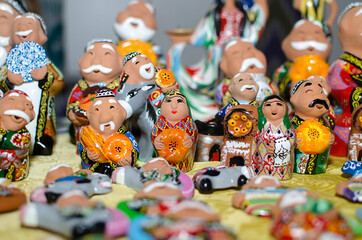 Traditional ceramic figurines of happy Uzbek men and women in national clothes with bread in hands