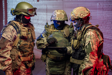 Three men in military outfit using tablet to find criminals