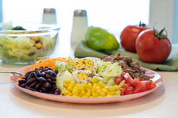 Fresh summer salads with mixed vegetables. Bowl with corn, green salad. Raw green paprika and tomato in the background. Healthy dish, healthy lifestyle  concept