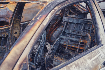 Burnt-out rusty cars on a city street, vandalism. Setting fire to cars by vandals and damage to property