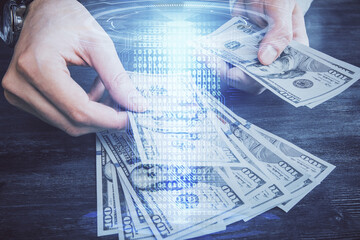 Multi exposure of technology drawing hologram and us dollars bills and man hands. Data concept