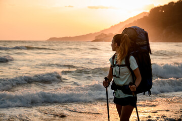 Close-up of charming woman tourist against the backdrop of sea and sunset