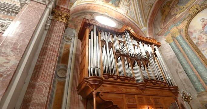 A man plays an old beautiful organ in Rome, Italy. The interior of the old roman church