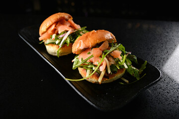 smoked salmon fish with vegetable salad mini burger bun canapés in dark background western appetiser halal menu