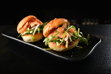 smoked salmon fish with vegetable salad mini burger bun canapés in dark background western...
