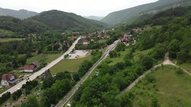 Drone Aerial View of Shargan Eight Railway and Jatare Train Station, Mokra Gora, Serbia. Narrow-gauge Railroad, Tourist Attraction and Green Landscape
