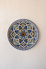 Traditional oriental ornamental plate on white cement wall background