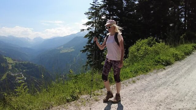 SLOW MOTION: Woman trekking on top of Brambruesch in Switzerland. Swiss tourist resort of Chur or Coira town. Chur skyline in Grisons canton.