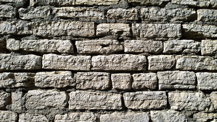 Old ancient stone abandoned wall background. Brick Texture backdrop. Copy space. Building facade renovation. Restoration and Reconstruction concept. Revival of architecture. Historical real estate.
