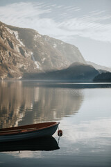 Fototapeta premium Tiny boat on still waters in Fjaerland, Norway