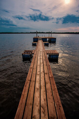 A pier on the lake for fishing. Dramatic, gothic and scary lonely atmosphere.