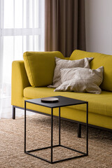 Stylish black coffee table and modern yellow couch