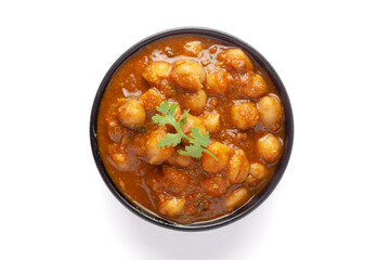 Chickpeas masala (Spicy chola or chhole curry)  garnished with fresh green coriander and ingredients. Served in a black bowl. A Classic Indian typical Panjabi street food.  In white background - obrazy, fototapety, plakaty