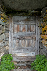 Weathered grungy wooden door with rusty slider