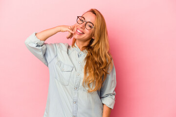 Caucasian blonde woman isolated on pink background showing a mobile phone call gesture with fingers.