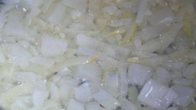 Sliced onion fried in sunflower oil close up