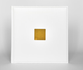 white book in leather binding with a gold metal insert for inscription.